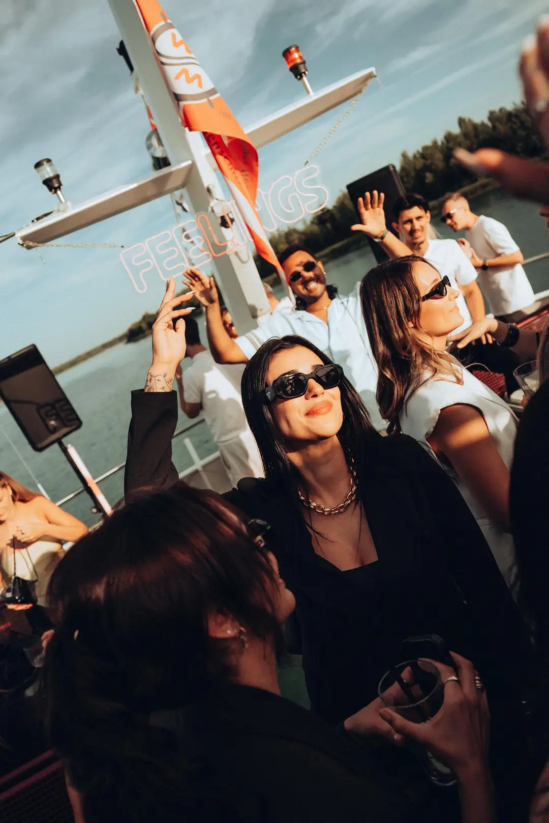 Guests dancing in sunglasses on the open deck