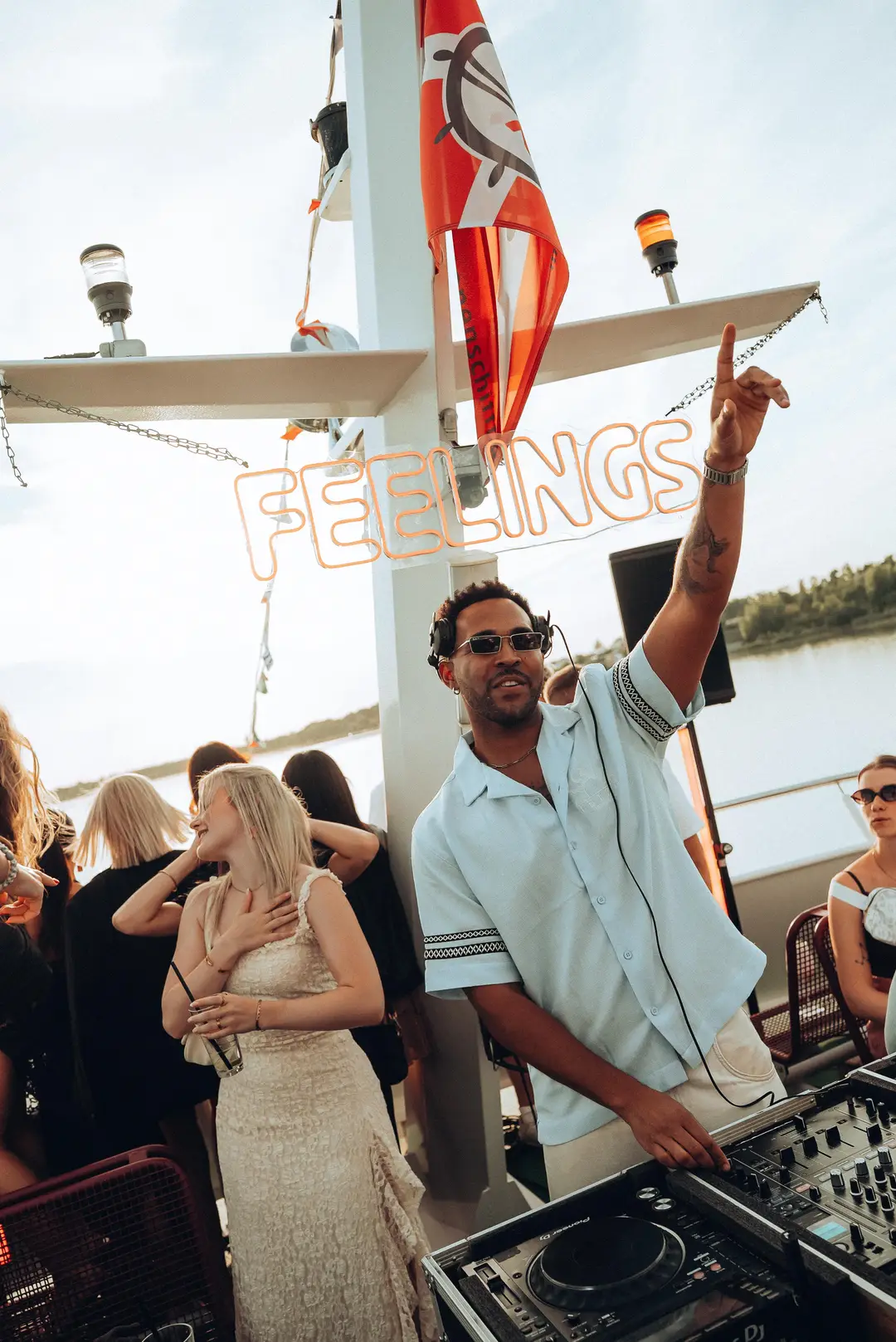 SEKOU pointing up beside the Feelings sign as the crowd dances