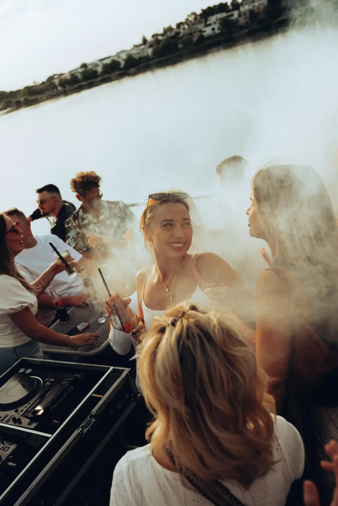 A guest smiling through sunlit haze on deck