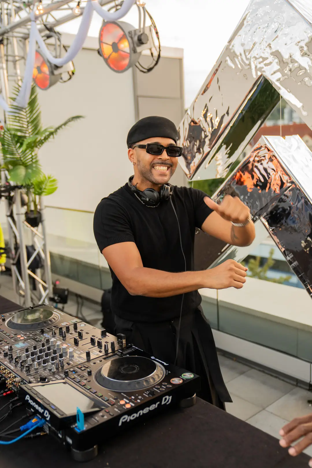 SEKOU laughing with a thumbs-up at the decks