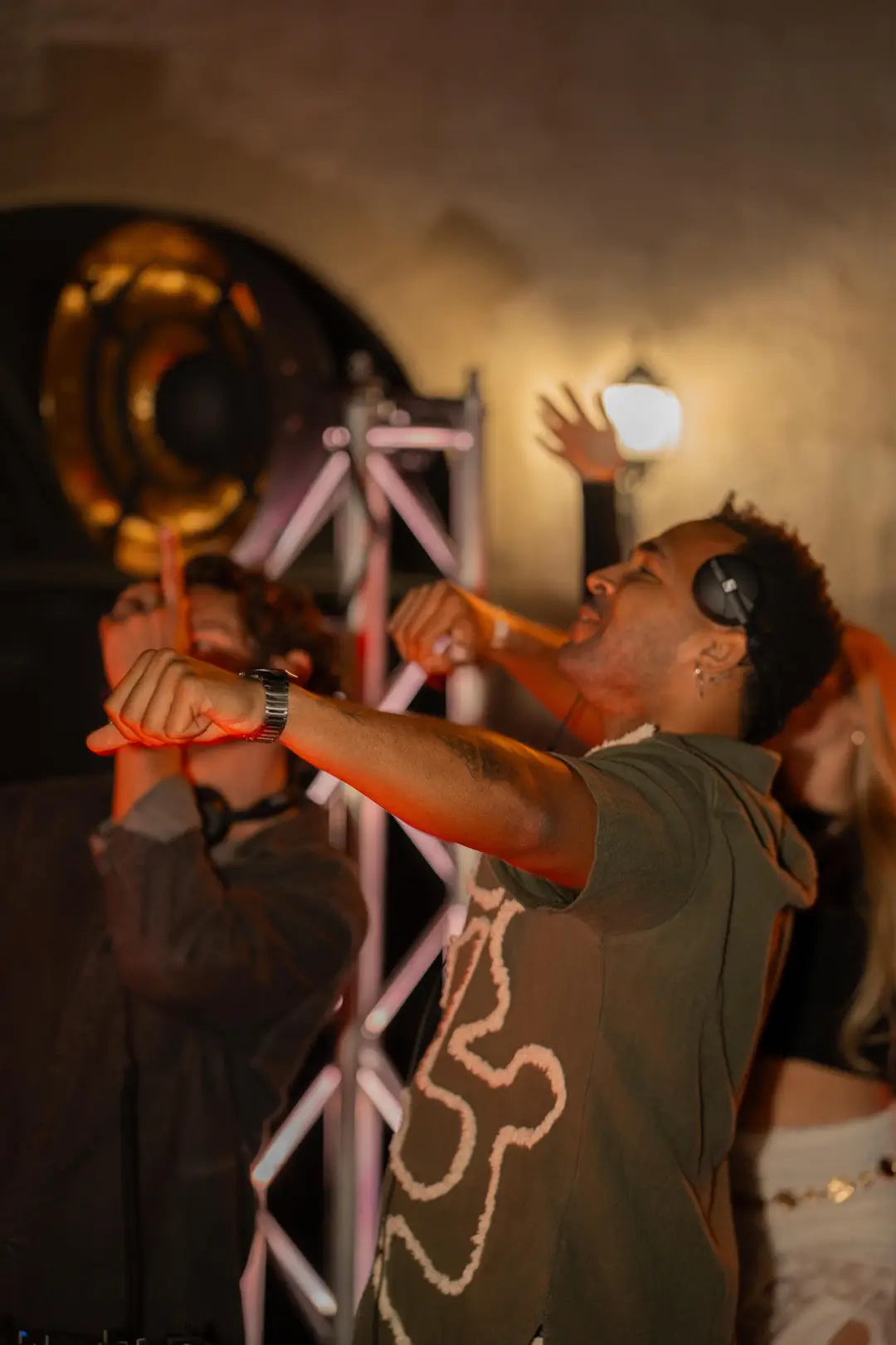 SEKOU with a hand raised in hazy backlight