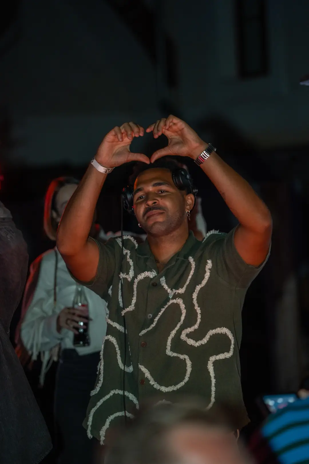 SEKOU making a heart with his hands above the crowd