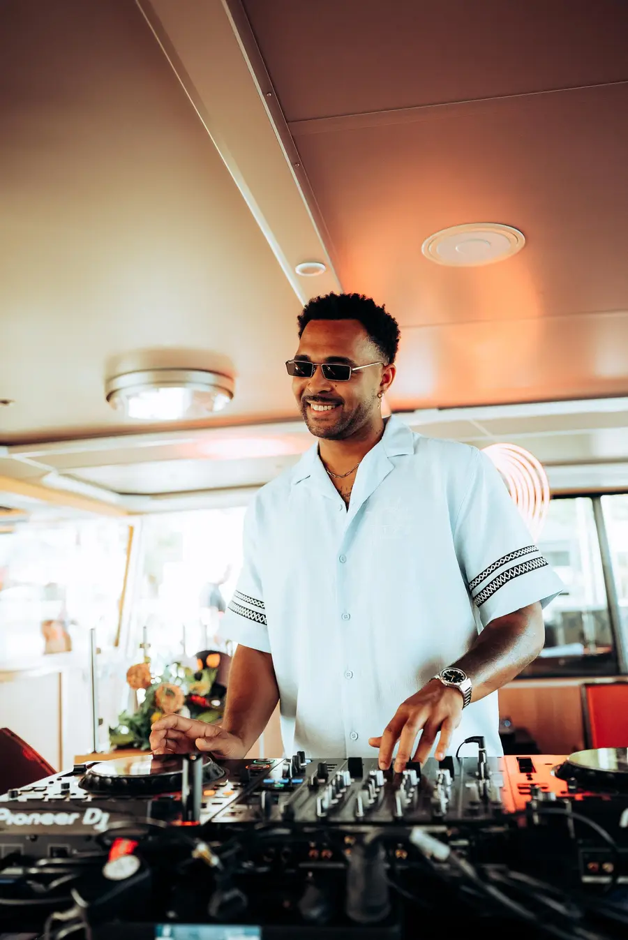 SEKOU in a linen shirt at the decks on a boat